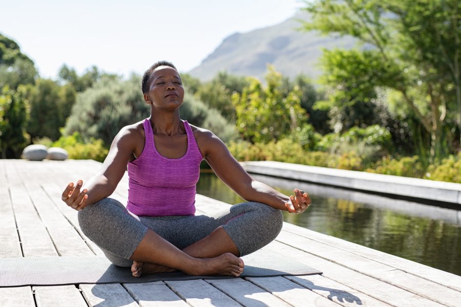 Woman in lotus, breathing outdoors