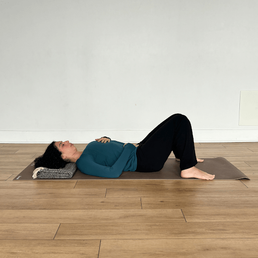 A person lying down doing a three part breath practice