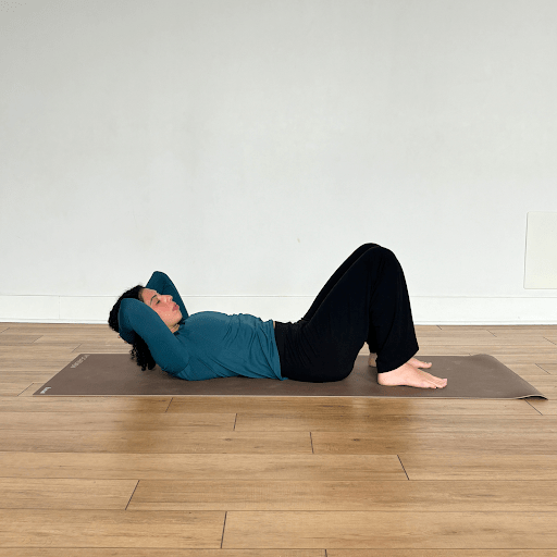 "Articulation of the spine" movement with a person lying on their back, hands behind their head, lowering their heck and neck back down towards the mat