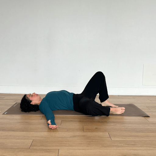 A person lying on their back, windshield wiping their knees