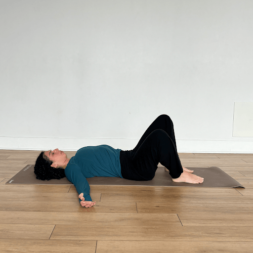 A person lying on their back, windshield wiping their knees