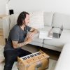 New Year's yoga flow image of Patrick Franco with a harmonium writing out his yoga sequence, looking at a laptop