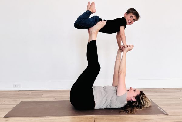 Kids yoga photo of Kate Lombardo with her toddler in flying airplane pose