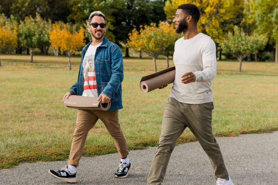 A photo of Patrick Franco and Jordan taking a mindful walk, carrying their rolled up yoga mats